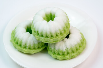 "Kue Putu Ayu"  steamed rice cakes found in Southeast Asian culinary traditions, often flavored with pandan and topped with grated coconut.