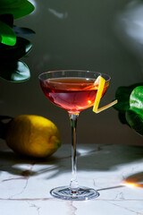 Strong alcoholic cocktail drink with gin, aperitif, bitters, liqueur and lemon twist with bar tools