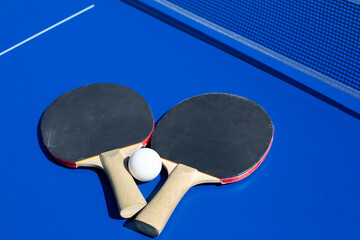 Two ping pong rackets on special table with net. Sports with rackets for active recreation and development of your body. Table tennis background. Set for playing ping pong
