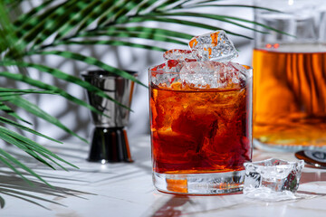The Bottom Line Strong alcoholic cocktail drink with scotch whiskey, sherry, liqueur, bitters and ice with bar tools