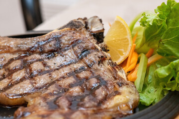 Grilled meat cooking on a barbecue with smoke rising, ready to be served at a feast