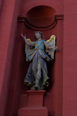 Fototapeta premium angel statue with golden wings at a red church