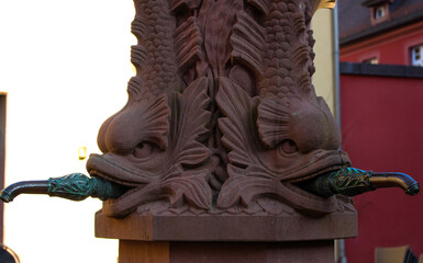 old stone fountain with fish-shaped taps,