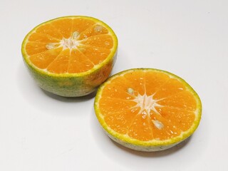 Fresh orange fruit cut in half, isolated on white background. Citrus photography, healthy tropical fruit, vitamin C, natural food, diet and nutrition concept.