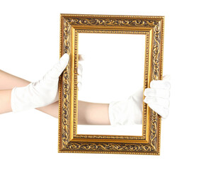 Hands in white gloves presenting an empty ornate vertical gilded picture frame with intricate carvings.