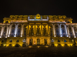 Budapest, Hungary – Illuminated facade of Buda Castle at night, historic Royal Palace architecture.