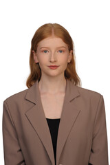 Portrait of an eighteen year old red-haired girl in a beige jacket on a white background.