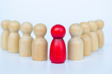 A red figure embraced by wooden figures, representing leadership or diversity or belonging concept