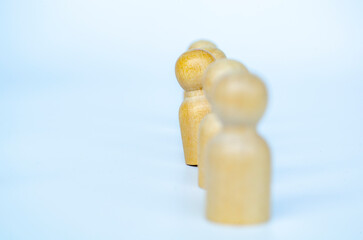A single red figure lifted apart from wooden figures, representing leadership or unfair treatment...