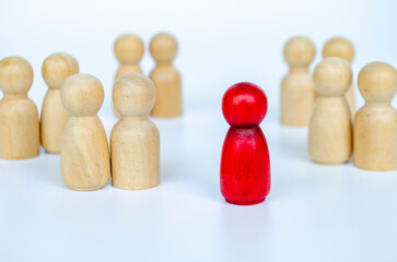 A red figure isolated away from wooden groups, representing leadership or rejection or...