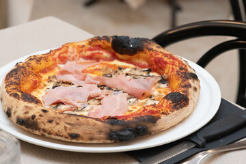 Freshly baked pizza coming out of the oven in a traditional Italian pizzeria setting