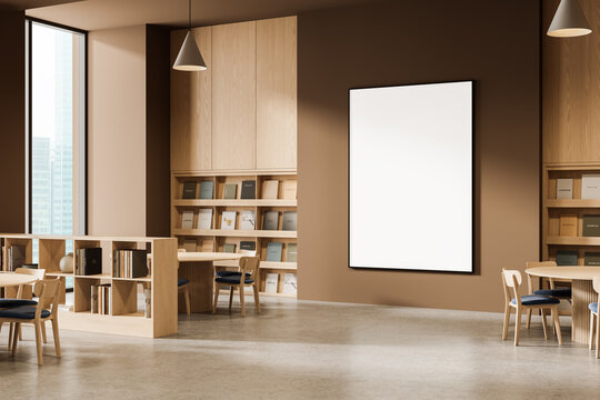 Empty vertical poster mockup on brown wall in modern library interior with wooden furniture and bookshelves under soft daylight from tall windows. 3D Rendering