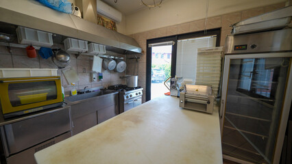 Professional butcher slicing meat in well-organized macelleria with tools and equipment
