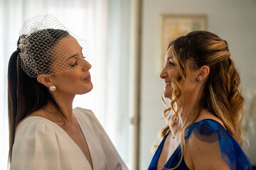 Naklejka premium Bride sharing a heartfelt moment talking with her sister before the wedding ceremony