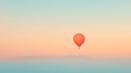 Obraz premium Lone orange hot air balloon ascends in a softly colored sky