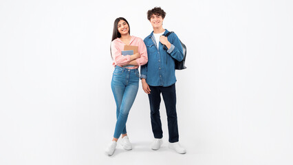 Obraz premium Educational Offer. Cheerful Young Students Duo Standing With Their Backpacks And Workbooks Over White Background. Full Length Studio Shot Of Boyfriend And Girlfriend Ready For College. Panorama