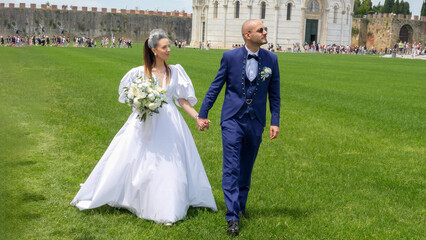 Fototapeta premium Happy newlyweds enjoying a festive celebration outdoors near famous city monuments and architecture