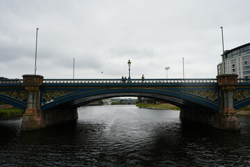Fototapeta premium Nottingham Princess, England - August 16 2025: Overcast day view of Trent Bridge with pedestrians crossing the river
