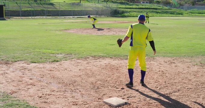 Pitcher fielding grounder throwing to White male first baseman catching glove securing out at park