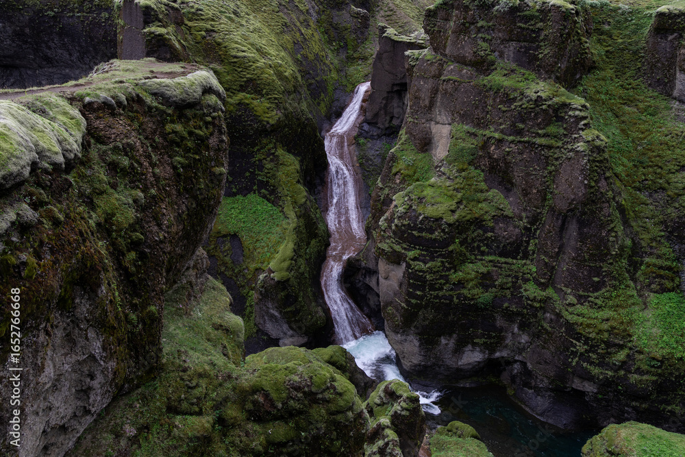 Canvas Prints a small waterfall flows between the cliffs.