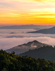 Obraz premium Sunrise over misty mountain range, golden light