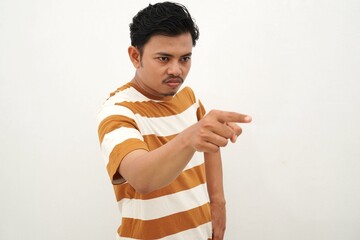 Young Asian man in white and brown striped t-shirt pointing directly at camera with serious...