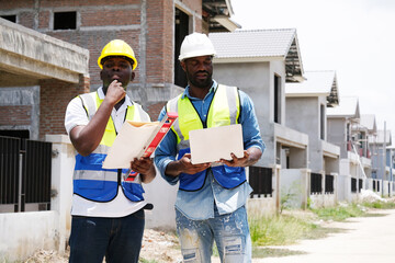 Male engineer and construction worker working at a construction site.