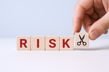 Risk Reduction Concept: Hand Cutting Risk with Scissors, Business Strategy, Finance, and Investment Management
