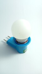 Energy Saving Light Bulb in Blue Electrical Socket on White Background