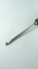 Flathead Screwdriver with Red Handle on White Surface