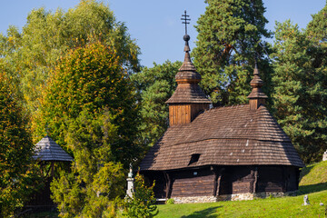 Wooden Church of St. Michael the Archangel in Inovce, Slovakia, standing amidst lush greenery