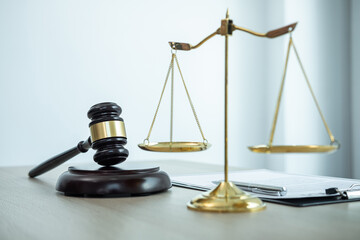 Judge gavel with Justice at law firm in background with legal case document contract, law and justice, attorney, lawsuit