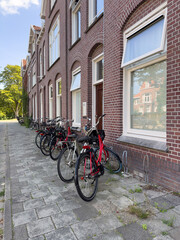 Row of parked bicycles along a brick sidewalk in a residential area, signaling the end of...