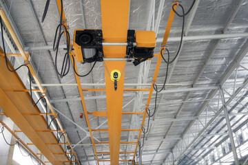 Overhead crane in factory or warehouse building. Industrial machine or lifting equipment with...