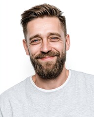 Fototapeta premium A handsome man with a beard, short hair cut, and a side-parted hairstyle is smiling and looking at the camera, isolated on a white background.