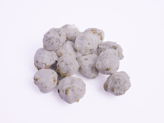 Spoiled candlenuts covered with mold, showing a white fuzzy layer and spots of decay, indicating...