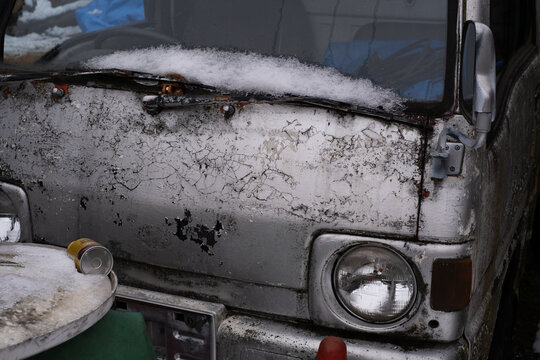 Fototapeta Weathered vintage car with cracked paint and snow detail
