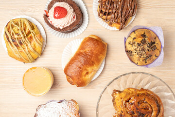 Overhead view of an assortment of pastries arranged on a wooden table, showcasing a variety of...