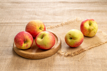 Sweet red apples on jute cloth, macro.