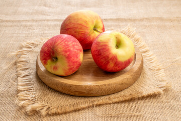 Sweet red apples on jute cloth, macro.