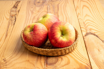 Sweet red apples on a wooden table, close-up.