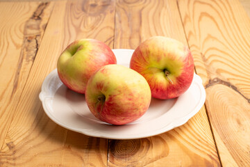 Sweet red apples on a wooden table, close-up.