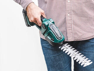 Handsome man, work clothes and hedge trimmer. Labor day. Close-up, indoors. Studio shot. Front...