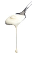 Creamy substance dripping from a spoon against a white background