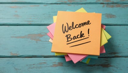 Colorful post-it notes with handwritten text Welcome Back. Conveying greeting, motivation, organization at work or school. Positive message, cheerful announcement in office. Concept return.