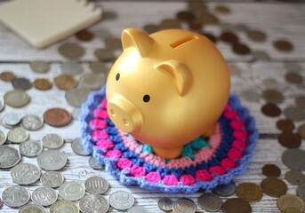 Cute nice lovely piggy bank golden on the crocheted doily cozy photo 
