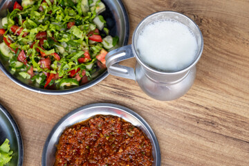 Macro shot of local Turkish ayran in a gray copper glass on a wooden background	