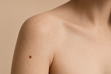 Naklejka premium Subtle Close-Up of Woman’s Shoulder with Mole Detail