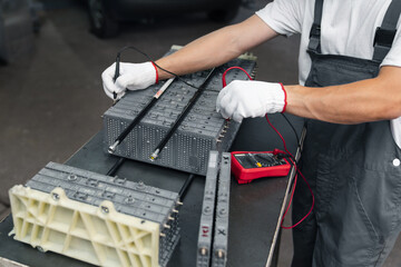 Serviceman repairs electric battery pack of hybrid car