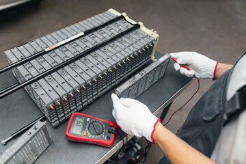 Serviceman repairs electric battery pack of hybrid car